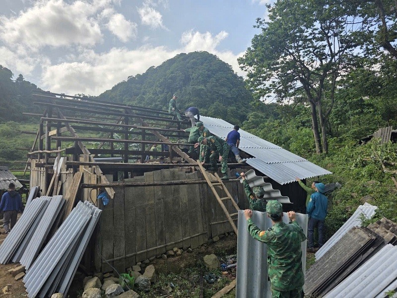 Cán bộ, chiến sĩ Đồn Biên phòng Cửa khẩu Quốc tế Trà Lĩnh cùng người dân xã Quang Hán khẩn trương gia cố mái nhà, khắc phục hư hỏng sau trận giông lốc kèm mưa đá đêm 28/4.